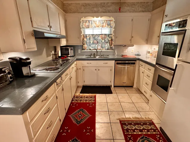 a kitchen with a sink a stove a microwave and cabinets