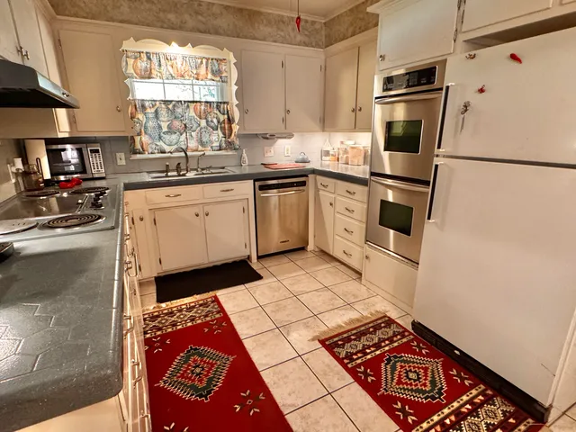 a kitchen with a sink a stove a refrigerator and cabinets