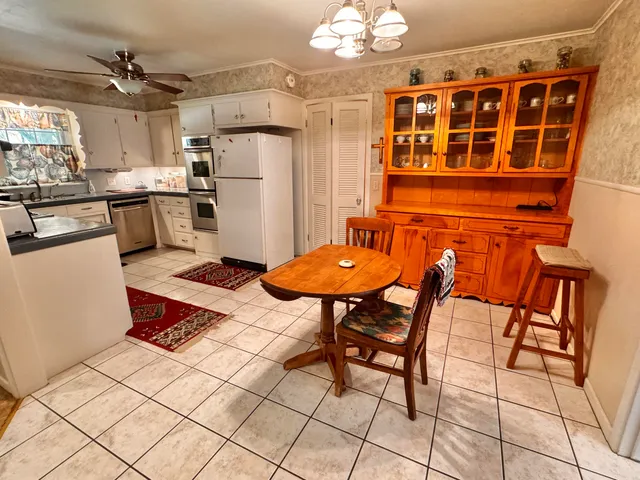 a kitchen with stainless steel appliances kitchen island granite countertop a table and chairs in it
