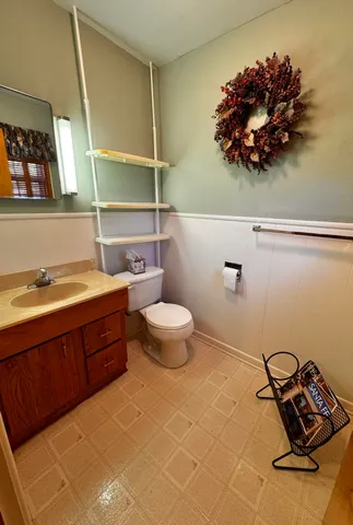 a bathroom with a toilet sink and mirror