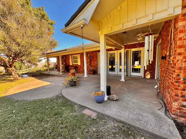 a backyard of a house with fountain table and chairs