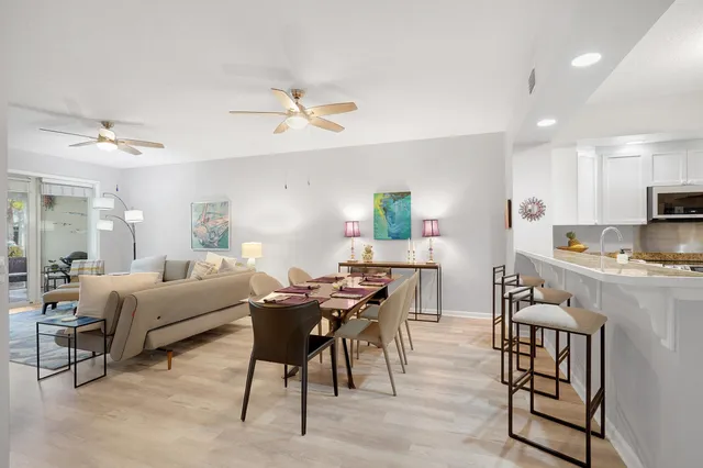 a living room with furniture a dining table and chairs with wooden floor