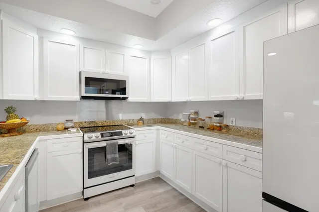 a kitchen with appliances a sink and cabinets