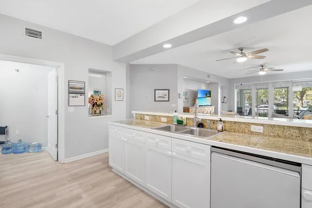 a kitchen with stainless steel appliances granite countertop a sink and a refrigerator