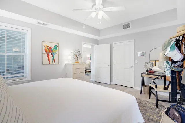 a bedroom with a large bed a chandelier and dresser