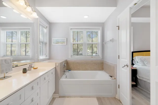 a bathroom with a tub a sink and a window