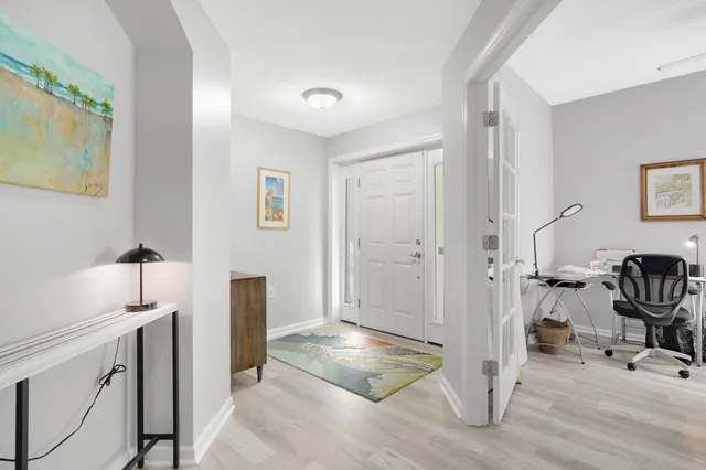 a view of a hallway with workspace and a window