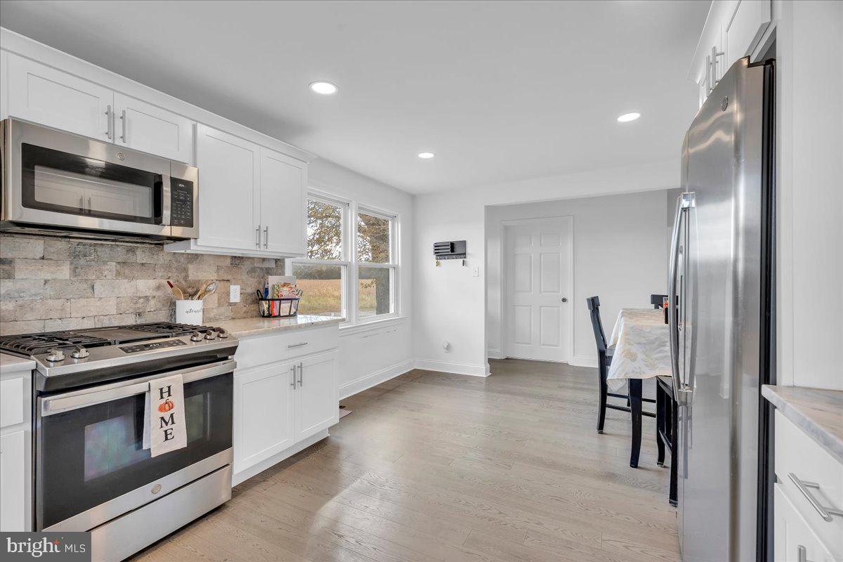 128 Cedarbrook Road Sicklerville, NJ 08081 - Photo 12 of 33 a kitchen with stainless steel appliances granite countertop white cabinets a stove top oven a sink and dishwasher