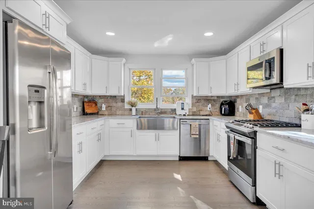 a kitchen with white cabinets and white appliances