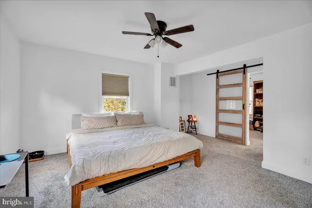 a bedroom with a bed and a ceiling fan