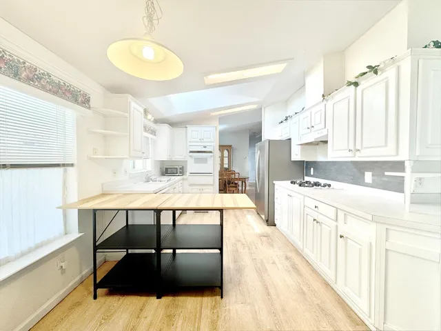 a kitchen with stainless steel appliances kitchen island granite countertop a sink and cabinets