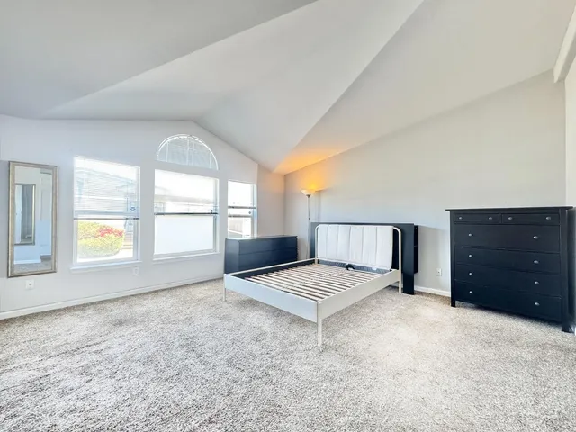 a spacious bedroom with a bed and a window