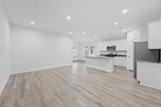 a view of kitchen with wooden floor and electronic appliances