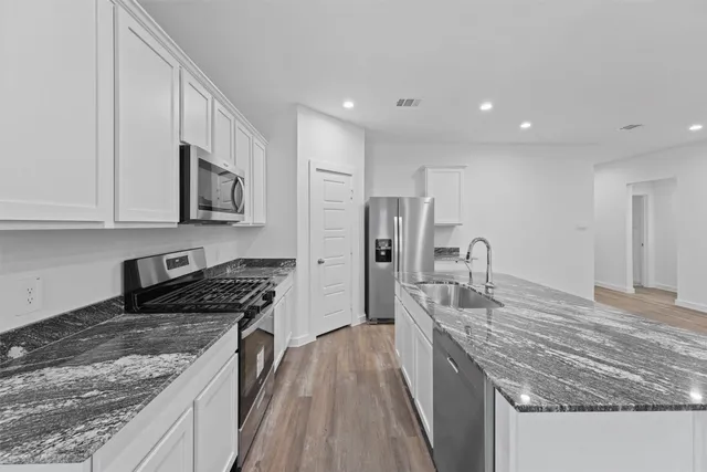 a kitchen with stainless steel appliances granite countertop a sink stove and refrigerator