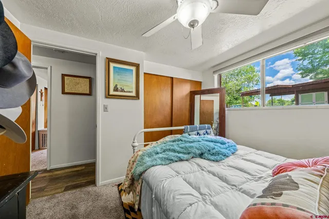 a bedroom with a bed and a painting on the wall