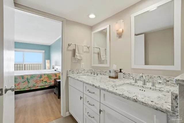 a en suite bathroom with a double vanity sink and a mirror