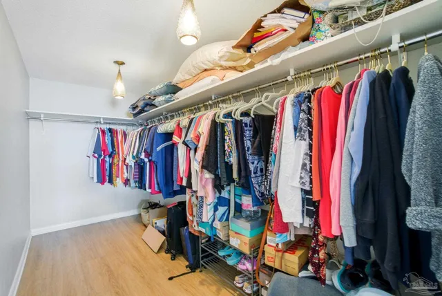 a view of walk in closet with clothes and shoes