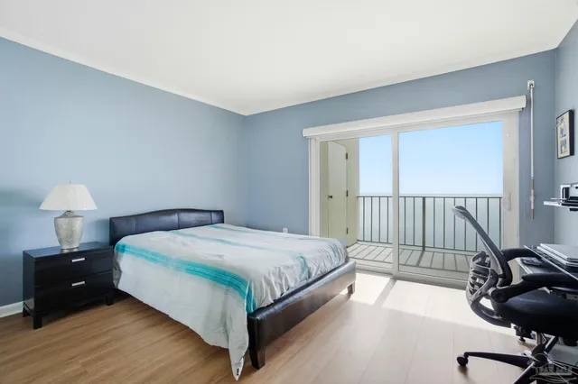 a bedroom with a bed and a chair with the view