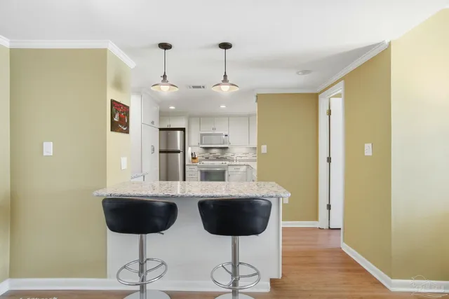 a kitchen with stainless steel appliances kitchen island granite countertop a dining table and chairs