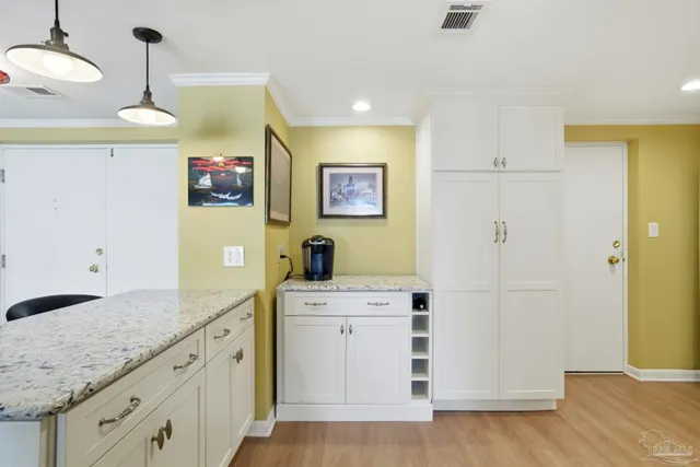 a kitchen with a sink cabinets and wooden floor
