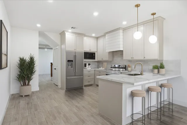 a kitchen with white cabinets and stainless steel appliances