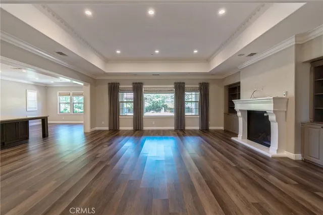 a kitchen with stainless steel appliances granite countertop wooden cabinets a sink dishwasher and a stove top oven with wooden floor