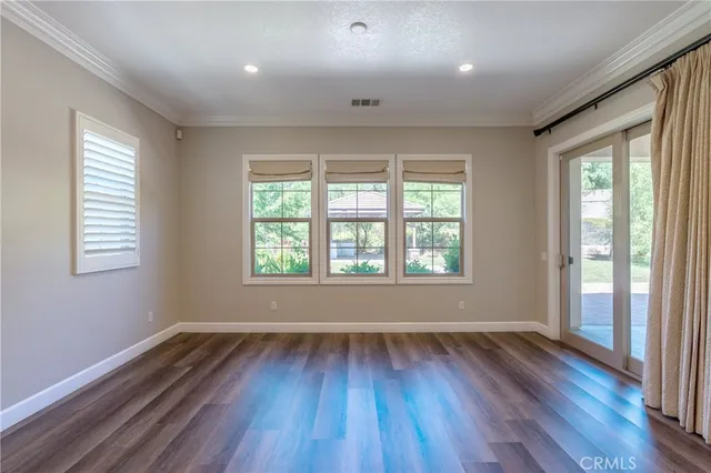 a view of an empty room with wooden floor