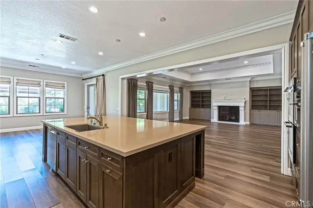 an empty room with wooden floor fireplace and windows