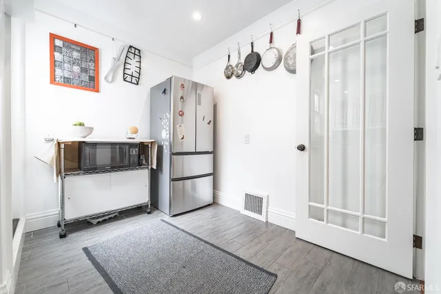 a view of a kitchen with fridge and wooden floor