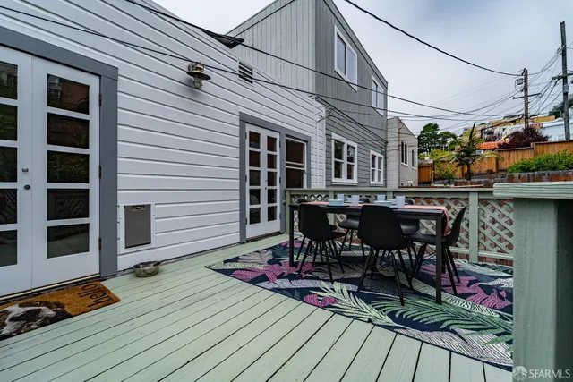 a patio with wooden floor a yard a fountain and a glass top table and chairs with wooden floor
