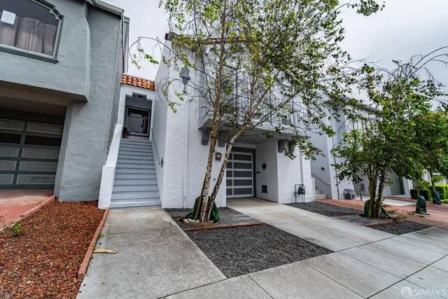 a front view of a house with a tree