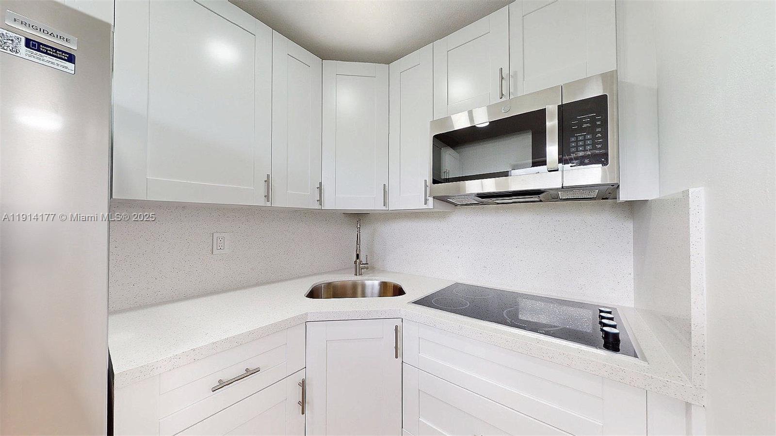 1201 Southwest 42nd Avenue, Unit 211 Miami, FL 33134 - Photo 4 of 19 a kitchen with stainless steel appliances white cabinets and a sink