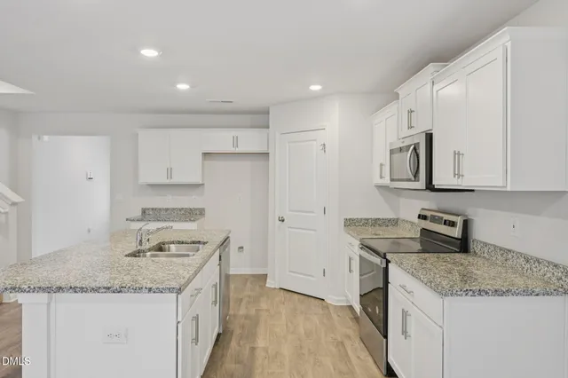 a kitchen view with stainless steel appliances granite countertop a sink stove and cabinets