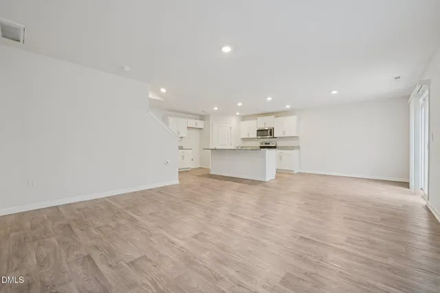 a view of kitchen with white cabinets and wooden floor