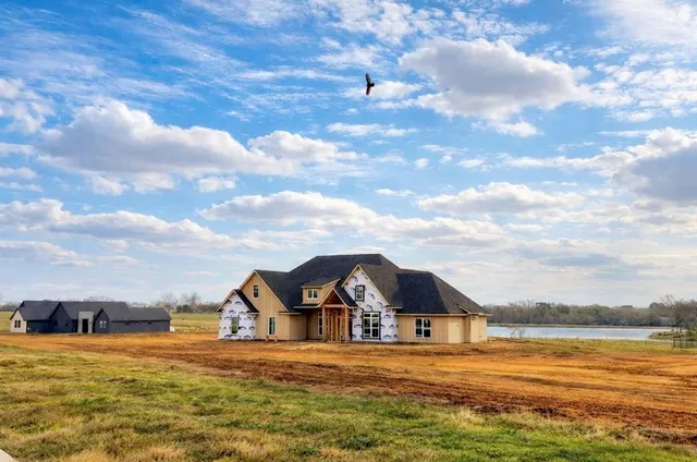 a view of a large house with a big yard and large trees