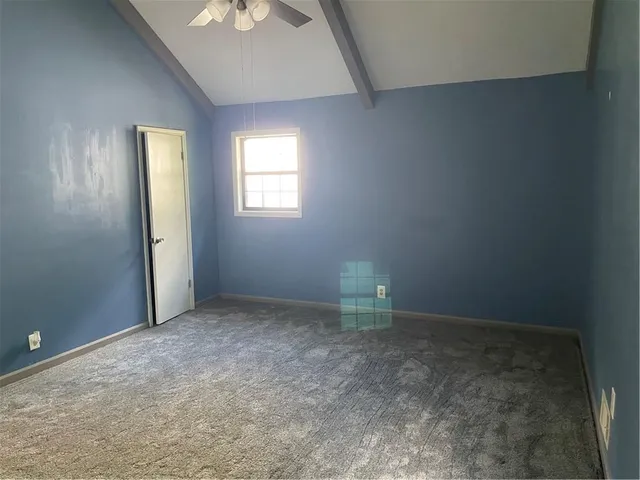 an empty room with a window and a refrigerator