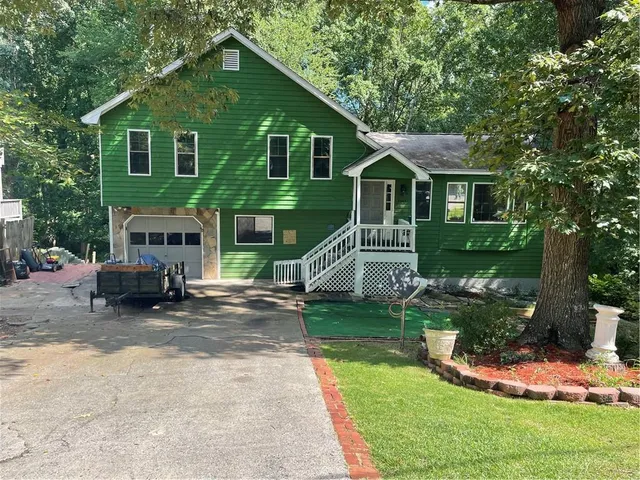 a view of a house with a yard and sitting area