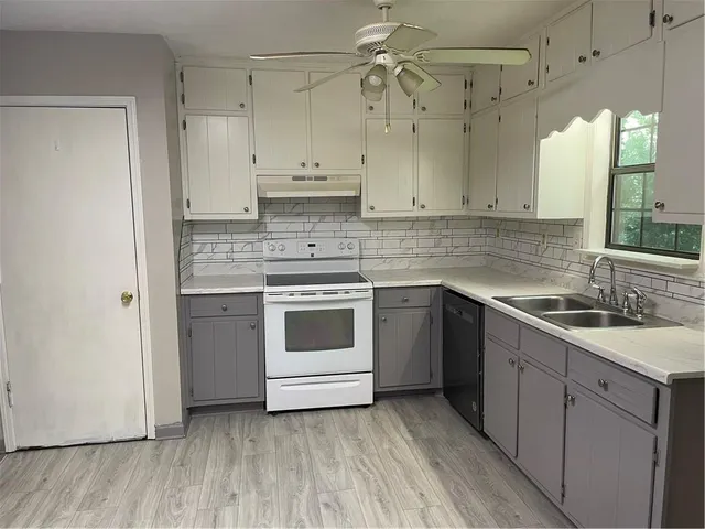 a kitchen with a white stove top oven sink and cabinets