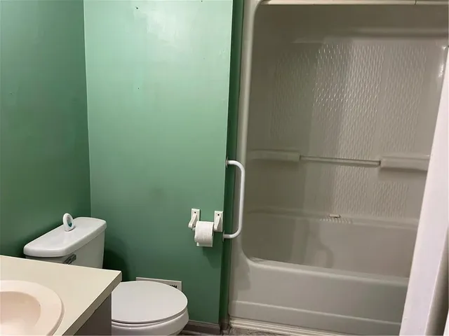 a white toilet sitting next to a bath tub