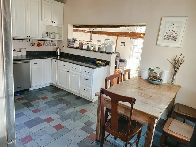 a kitchen with a stove a sink and chairs