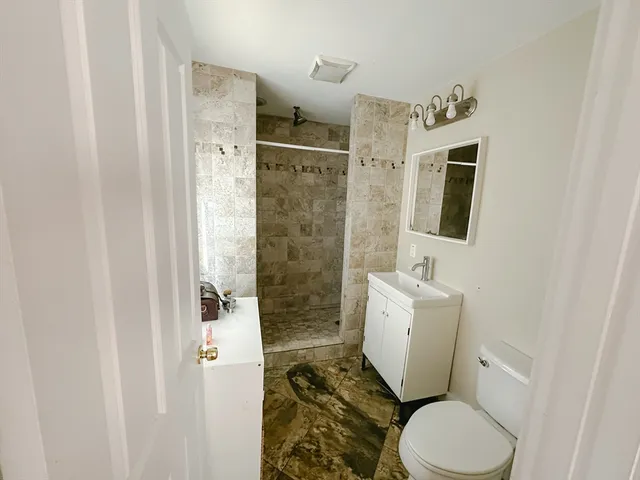 a bathroom with a toilet sink and shower curtain