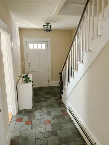 a view of a hallway with stairs and a window