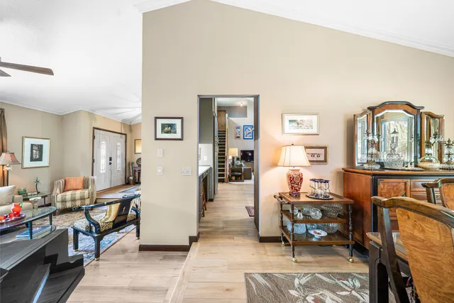 a kitchen with stainless steel appliances a dining table chairs refrigerator and sink