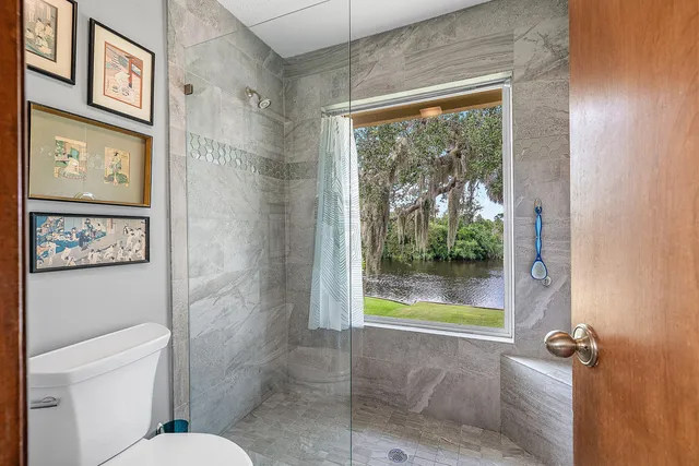 a bathroom with a shower sink vanity mirror and toilet