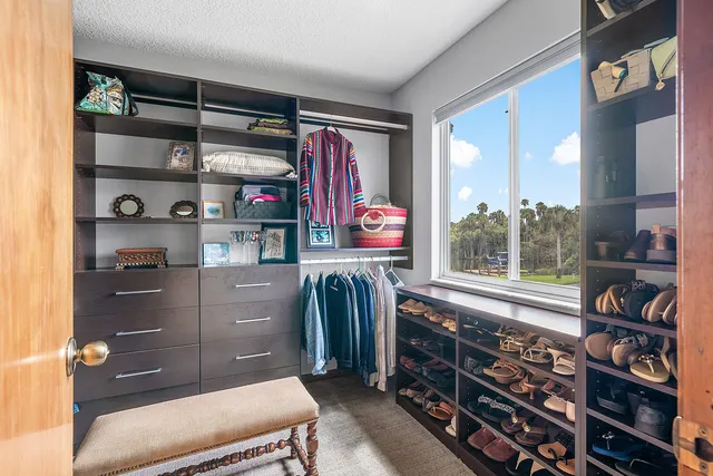 a bedroom with a bed a wall painting and a window