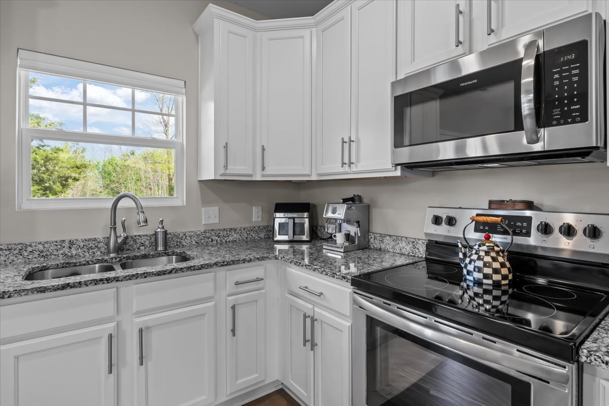 10011 Wendy Way Lyles, TN 37098 - Photo 8 of 51 a kitchen with stainless steel appliances granite countertop white cabinets and a stove top oven