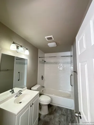 a bathroom with a bathtub shower sink vanity and toilet