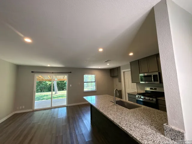 a kitchen with granite countertop kitchen island wooden floors granite counter tops and window
