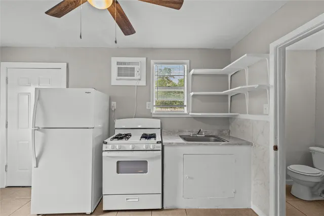 a white refrigerator freezer and a stove sitting inside of a kitchen