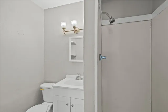 a bathroom with a toilet a sink and mirror